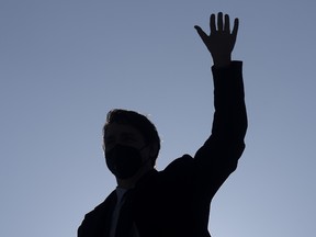 Silhouette of Justin Trudeau waving against a blue sky