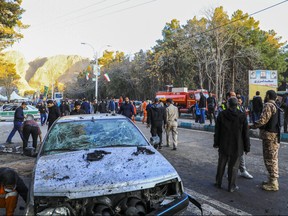 This picture shows people and Iranian emergency personnel at the site where two explosions in quick succession struck a crowd marking the anniversary of the 2020 killing of Guards general Qasem Soleimani, near the Saheb al-Zaman Mosque in the southern Iranian city of Kerman on Jan. 3, 2024.