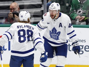 Maple Leafs' Morgan Rielly (right) is congratulated by teammate William Nylander after scoring against the Dallas Stars on Thursday, Oct. 26, 2023, in Dallas.