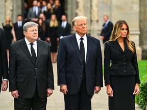 Donald Trump (centre) stands with his wife Melania