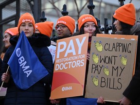 People hold placards calling for better pay for junior doctors