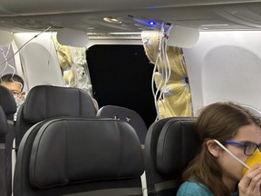 This image provided by Kelly Bartlett shows passengers near a hole in the fuselage of an Alaska Airlines Boeing 737 Max 9, Flight 1282, which was forced to return to Portland International Airport on Friday, Jan. 5, 2024.