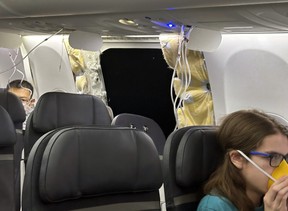 This image provided by Kelly Bartlett shows passengers near a hole in the fuselage of an Alaska Airlines Boeing 737 Max 9, Flight 1282, which was forced to return to Portland International Airport on Friday, Jan. 5, 2024.
