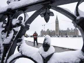 A worker prepares a pathway on Parliament Hill following a snowfall in Ottawa.