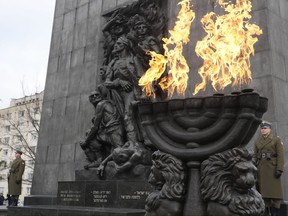 Fire burns in a giant menorah during ceremonies on the eve of the 79th anniversary of the liberation of the Nazi German death camp of Auschwitz-Birkenau by Soviet troops, at the Monument to the Heroes of the Ghetto, in Warsaw, Poland, on Friday, Jan.26, 2024.