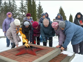 Women lay flowers in memory of those who were killed in the plane on Wednesday, at the memorial to soldiers who died in the Great Patriotic War "Enternal Flame" in Belgorod, Russia, Thursday, Jan. 25, 2024.