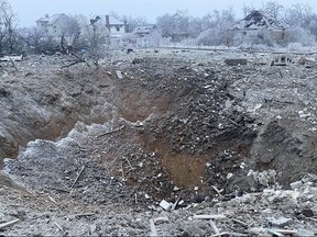 In this photo provided by the Ukrainian Emergency Service, a crater of an explosion is seen next to the private building destroyed after a Russian missile attack in Novomoskovsk, near Kryvyi Rih, Ukraine, Monday, Jan. 8, 2024.