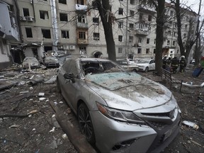 A damaged car is parked in the yard of a residential building damaged by a Russian missile strike in Kharkiv, Ukraine, Tuesday, Jan. 2, 2024.
