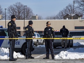 Law enforcement officers stand outside a school
