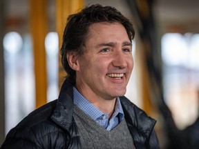 Prime Minister Justin Trudeau smiles at the media before a news conference for a housing announcement in Vancouver Friday, Dec. 15, 2023.