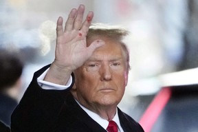 Former U.S. president Donald Trump waves as he leaves his apartment building in New York, Wednesday, Jan. 17, 2024.