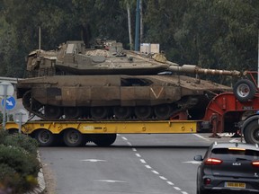 An Israeli military truck transports a tank in the Upper Galilee in northern Israel near the border with Lebanon on Jan. 5, 2024.