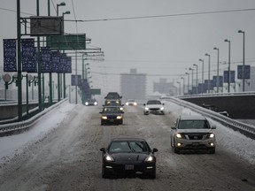 Motorists travel on the snow-covered Cambie Bridge as freezing rain falls in Vancouver, on Friday, Dec. 23, 2022.