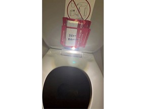 An iPhone is taped to the back of a toilet seat