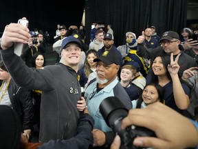 Michigan quarterback J.J. McCarthy takes a picture with fans