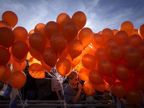 Demonstrators hold orange balloons at a rally