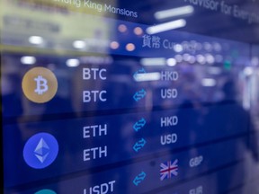 The Bitcoin, top, and Ethereum, bottom, logos on a screen at a cryptocurrency exchange in Hong Kong, China, on Tuesday, Dec. 5, 2023. Bitcoin shrugged off a dip in global stock markets to set another more than 19-month high, a sign of its decoupling from other assets.