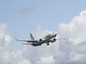 An Alaska Airlines Boeing 737-9 Max flies above Paine Field near Boeing's manufacturing facility in Everett, Wash., Monday, March 23, 2020, north of Seattle.