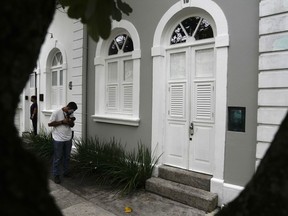 A journalist photographs the entrance to the apartment where Brent Sikkema was killed
