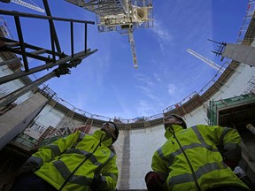Employees look up at the construction site of Hinkley Point C nuclear power station in Somerset, England, Tuesday, Oct. 11, 2022.