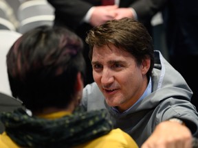 Prime Minister Justin Trudeau speaks with a member of the public at an event follwing the signing of the Nunavut devolution agreement in Iqaluit, Thursday, Jan. 18, 2024.