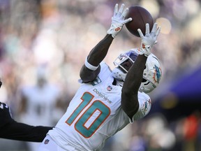 Miami Dolphins wide receiver Tyreek Hill (10) catches a pass for a first down against the Baltimore Ravens during the first half of an NFL football game in Baltimore, Sunday, Dec. 31, 2023.