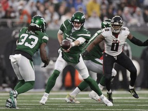 New York Jets quarterback Tim Boyle (7) hands off the ball to New York Jets running back Dalvin Cook (33) during the third quarter of an NFL football game, Sunday, Dec. 3, 2023, in East Rutherford, N.J.