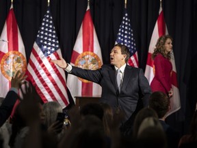 Florida Gov. Ron DeSantis (right) throws pens into the crowd after signing education bills at Cambridge Christian school in Tampa on May 17, 2023.