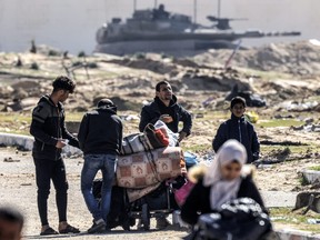 An Israeli battle tank is deployed to guard a position as displaced Palestinians flee from Khan Yunis in the southern Gaza Strip on Jan.30, 2024, amid the ongoing conflict between Israel and the Palestinian militant group Hamas.