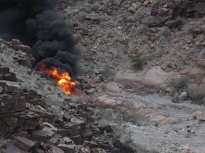 A survivor, lower right, walks away from the scene of a deadly tour helicopter crash