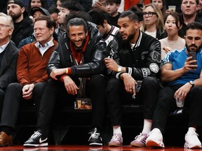 Colin Kaepernick (centre left) and Akim Aliu (centre right) watch the Toronto Raptors play the Boston Celtics during NBA action in Toronto, Monday, Dec. 5, 2022. Aliu had high hopes for Kim Davis -- especially after their early dialogue.The NHL's executive vice-president of social impact, growth initiatives and legislative affairs seemed open, Aliu thought at the time, to ideas put forward by the Hockey Diversity Alliance, an organization started by a group of current and former players of colour looking to share their experiences and in hopes of bettering the sport.