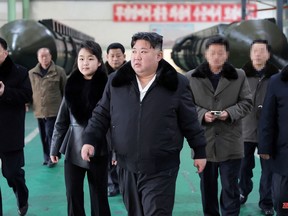 This undated picture released from North Korea's official Korean Central News Agency (KCNA) via KNS on Jan. 5, 2024 shows North Korea's leader Kim Jong Un (centre) inspecting an important military vehicle production plant with his daughter Ju Ae (centre left) at an undisclosed location in North Korea.