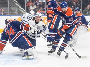 Toronto Maple Leafs' Tyler Bertuzzi (59) crashes into Edmonton Oilers goalie Stuart Skinner (74) as Mattias Janmark (13) picks up the rebound during first period NHL action in Edmonton on Tuesday Jan. 16, 2024.