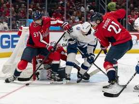 Washington Capitals defenceman Trevor van Riemsdyk (57) and centre Aliaksei Protas (21) defend against Tampa Bay Lightning center Anthony Cirelli (71) during the second period of an NHL hockey game Saturday, Dec. 23, 2023, in Washington.