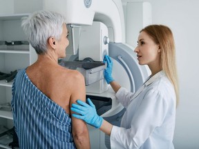 A woman gets a mammography scan at a hospital with a medical technician.