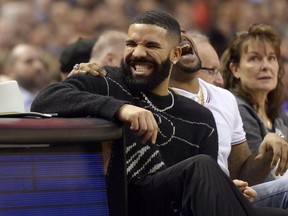 Drake has a laugh courtside during NBA action