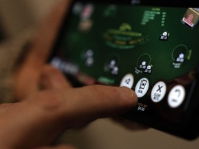 A "deal" button on a casino app is shown on a smartphone in a photo illustration made in Toronto, Wednesday, Jan. 17, 2024.