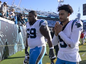 Carolina Panthers quarterback Bryce Young and guard Gabe Jackson leave the field after their loss against the Jacksonville Jaguars in an NFL football game Sunday, Dec. 31, 2023, in Jacksonville, Fla.
