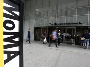 People walk by the entrance to the Museum of Modern Art, in New York, April 22, 2014.