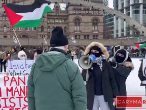 Protesters clash with a senior skating at Nathan Phillips Square in a screenshot from video.