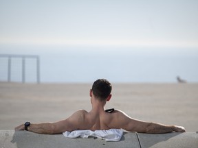 A man sunbathes on San Sebastian beach in Barcelona on Jan. 26, 2024 as temperatures around 30C were recorded in Spain.