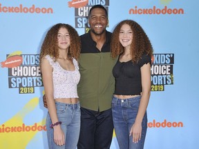 FILE - Michael Strahan, center, and his daughters Sophia Strahan, left, and Isabella Strahan arrive at the Kids' Choice Sports Awards on Thursday, July 11, 2019, at the Barker Hangar in Santa Monica, Calif. Isabella, the 19-year-old daughter of NFL Hall of Famer and Good Morning America host Michael Strahan, is under treatment for brain cancer.