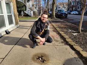 Winslow Dumaine poses near a rodent-shaped mark in the sidewalk that's become a tourist attraction known as the "Chicago Rat Hole." MUST CREDIT: Courtesy of Winslow Dumaine