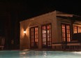 The Aegean Villa lit up at night as viewed from the pool.