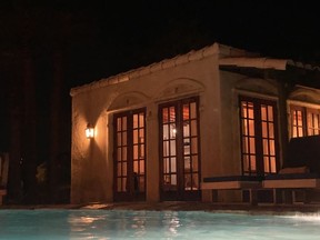 The Aegean Villa lit up at night as viewed from the pool.