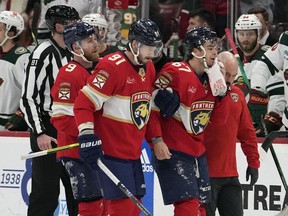 Florida Panthers right wing William Lockwood (67) is helped off the ice after fighting with Minnesota Wild right wing Brandon Duhaime during the first period of an NHL hockey game, Friday, Jan. 19, 2024, in Sunrise, Fla.