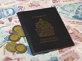 Canadian passport on top of foreign currency