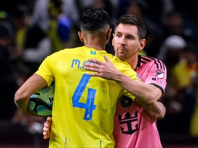 Inter Miami's ionel Messi embraces Nassr's Saudi defender Mohammed al-Fatil.