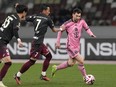 Inter Miami's Lionel Messi, right, battles for the ball against Vissel Kobe's Yosuke Ideguchi.