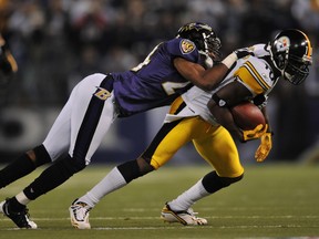 Domonique Foxworth of the Baltimore Ravens tackles Santonio Holmes of the Pittsburgh Steelers during a game in 2009.